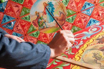 Hand of a sicilian cart painter while finishing some colored details.  Workshop of the sicilian folkloric craftsmanship Rosso Cinabro, Ragusa Ibla - 141879396
