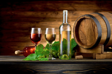 Wine bottle and glasses with wooden barrel on the table