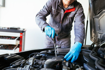 Auto mechanic repairing car. Selective focus on hands. 