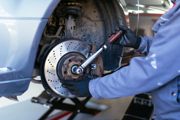 Man fixing brake disk. Selective focus.