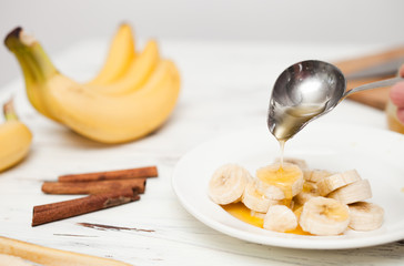 A bunch of bananas and a cut banana on a plate.