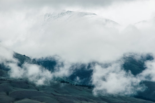 Snow-capped mountains in the clouds. Nature background