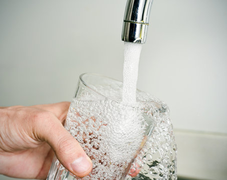 man filling a glass of tap water