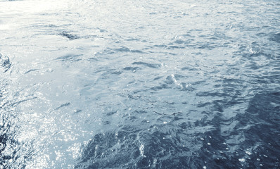 Water surface with ripples and sunlight reflections