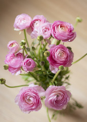Obraz na płótnie Canvas Pink ranunculus flower bouquet on a wooden background