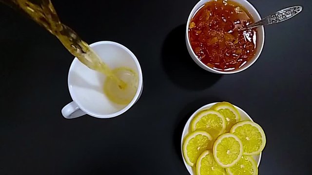 Close-up of pouring tea in white mug, slow motion hd video, top view