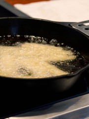 Potato Being Fried in Cast Iron Skillet