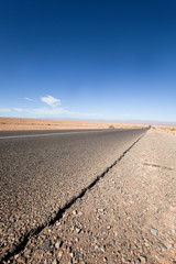 route droite au milieu d'un désert de sable 