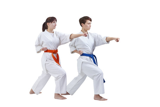 Women in karategi are training punch arm on a white background