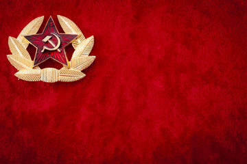 Old Soviet badge with the red star, laurel wreath, a sickle and a hammer reminiscent of the cold...