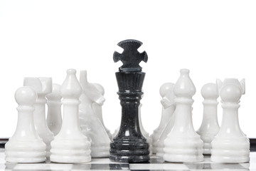 Black king and white chessmen on chessboard