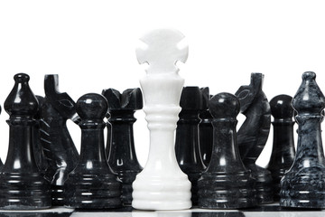 White king and black chessmen on chessboard