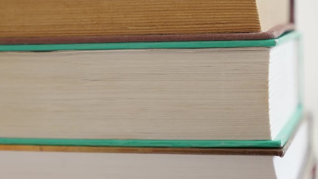 Tilting on old books darkened with shelf dust stacked 4K 2160p 30fps UltraHD footage - Close-up of vintage deckle edge paper material or archives slow tilt 3840X2160 UHD video 