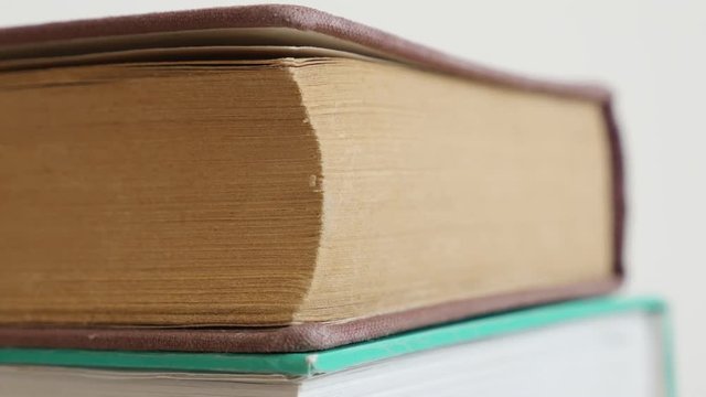 Old books darkened with shelf dust stacked 4K 2160p 30fps UltraHD tilting footage - Close-up of vintage deckle edge paper material or archives slow tilt 3840X2160 UHD video 