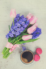 Obraz na płótnie Canvas Pink tulips and blue hyacinths flowers with cup of coffee, holiday breakfast, retro toned