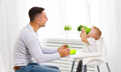 father feeds baby from spoon