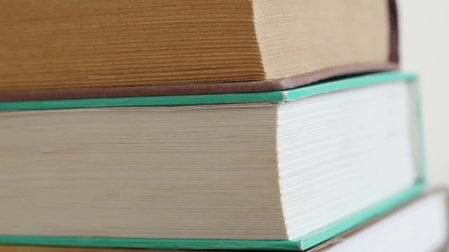 Close-up of vintage deckle edge paper material or stacked archives 4K 2160p 30fps UltraHD tilting footage - Pile of old books darkened with shelf dust slow tilt 3840X2160 UHD video