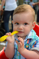 Baby Kind entdeckt spielerisch einen Löffel beim Essen
