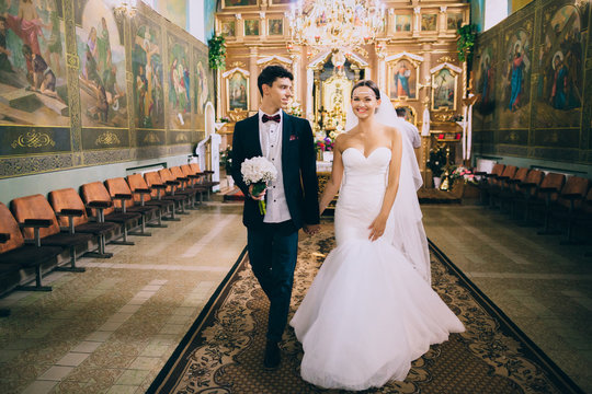 Happy Wedding Couple Walking Out Of Church