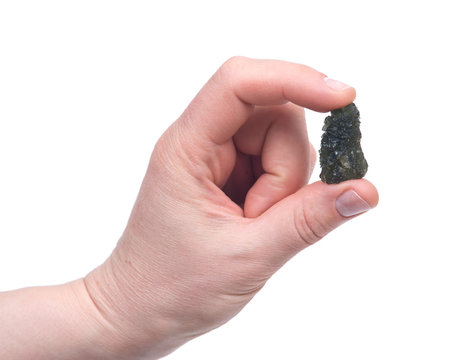 Young woman holding moldavite - form of tektite found along the banks of the river Moldau in Czech republic, isolated on white background