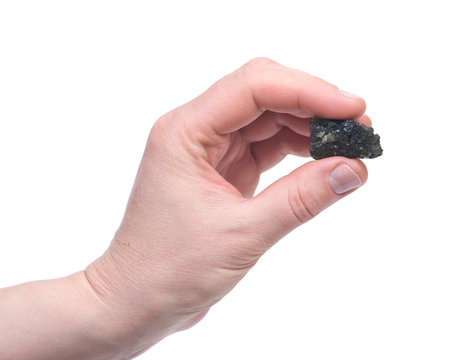 Young woman holding moldavite - form of tektite found along the banks of the river Moldau in Czech republic, isolated on white background
