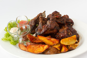 Свиные ребра приготовленные на гриле с печенным картофелем.