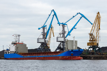 Blue cargo ship loading in the port of Riga, Europe