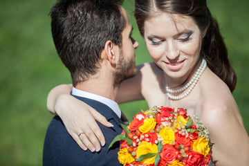 Wife and groom on grass field in sunny summer day