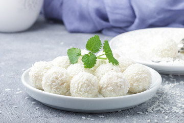 Homemade coconut candies in a white plate on the table. Sweets. Selective focus