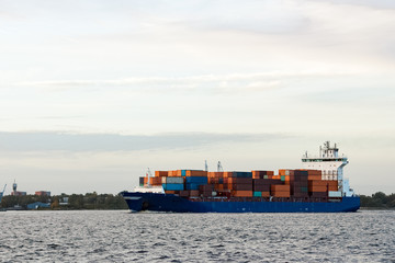 Blue container ship moving to Baltic sea. Riga, Latvia