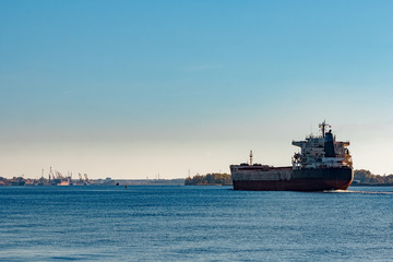 Fototapeta na wymiar Black cargo ship entering Riga, Europe