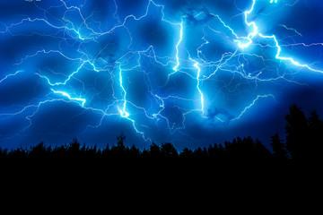 Lightning strike on a dark blue sky over the forest silhouette