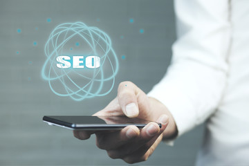 Business man hand phone and  SEO text on screen