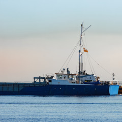 Blue cargo ship leaving Riga and entering Baltic sea