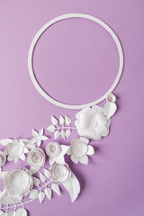 round frame with white paper flowers on purple background. Cut from paper. Place your text