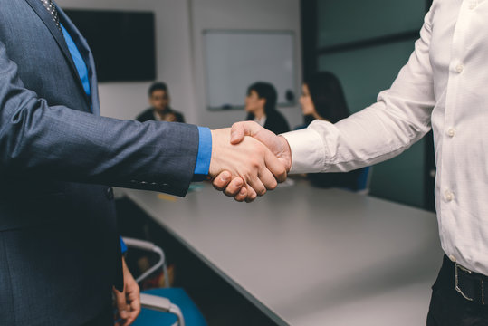 Two men handshaking in an office after successfull contract