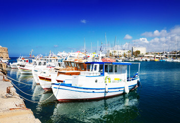 Fototapeta na wymiar colorful fishing boats near old fortress, Heraklion port, Crete, Greece, retro toned