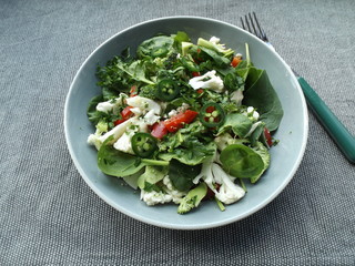 Spinach salad with raw broccoli and cauliflower.