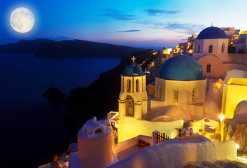 Oia village with blue church domes at night at night, Santorini, Greece, toned