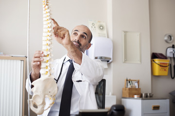 Doctor pointing on spinal disk while working in hospital