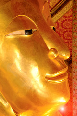Face of reclining Buddha gold statue.