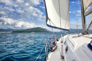 Fototapeta na wymiar Front part of a sailboat, set on full sails to the sea