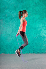 Fitness concept. Healthy lifestyle. Young slim woman jumping with skipping rope