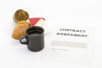 Contract agreement with coffee, bread, and cheese