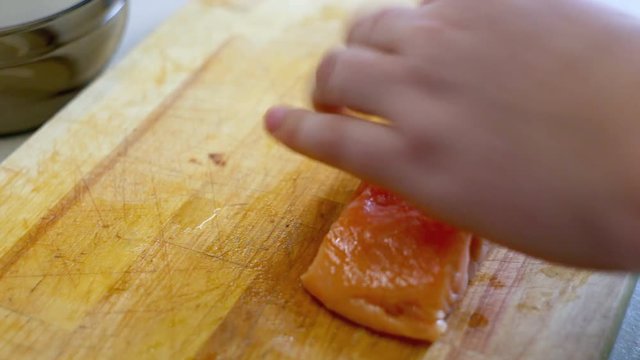The chef cuts salmon fillets for cooking