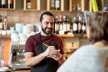 man or waiter serving customer at bar