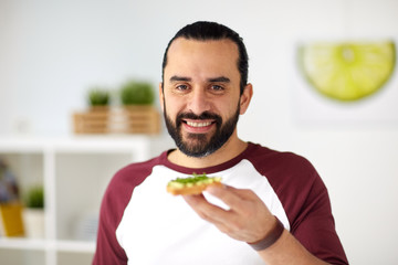 man eating avocado sandwiches at home kitchen