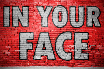 In Your Face Ziegelsteinmauer Graffiti
