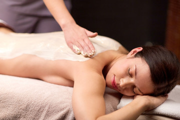 woman lying and having back massage at spa