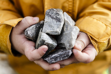 grey stones in cute small child hands